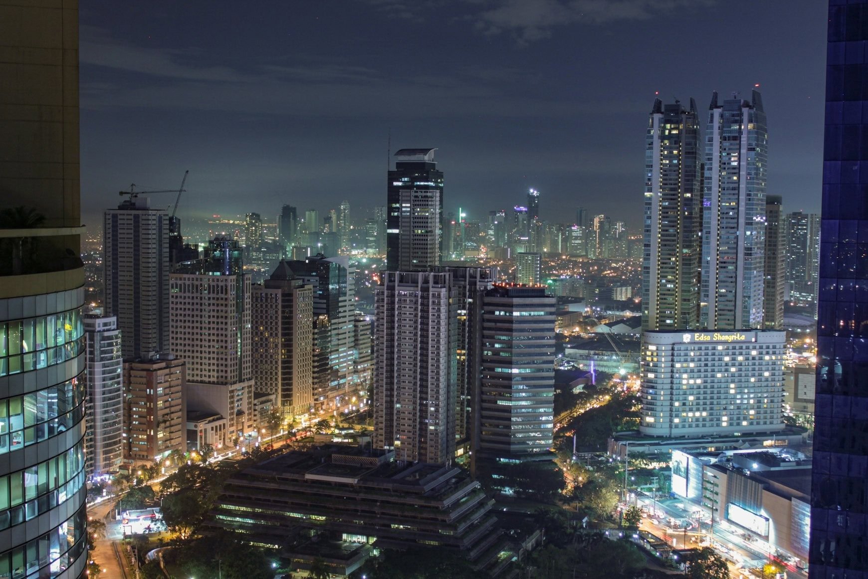 A nighttime cityscape with tall skyscrapers and city lights illuminating the APAC Talent Hub