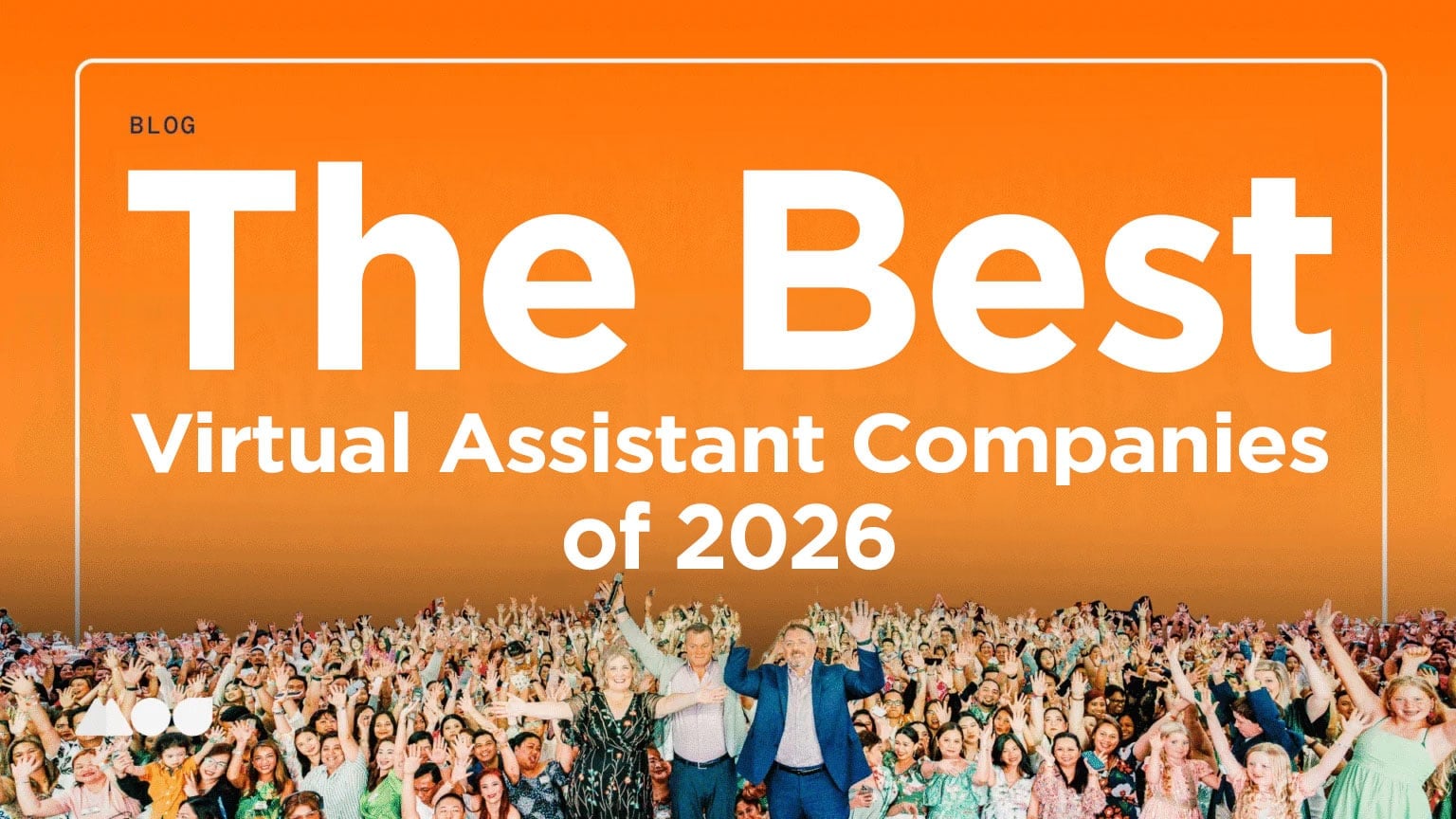 A large crowd of people cheer and raise their hands beneath a bright orange banner that reads, “The Best Virtual Assistant Companies of 2026.”.